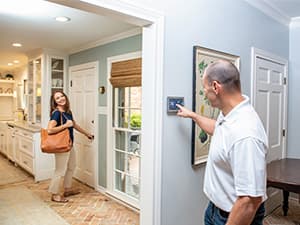Smart Thermostat Installation & Energy Savings Homeowner adjusting smart thermostat before leaving home in Granite Bay, CA