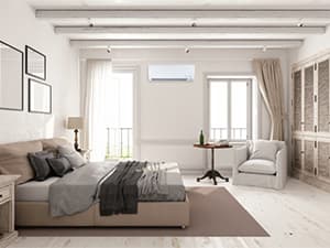 Ductless mini-split system for bedroom comfort Wall-mounted ductless mini-split system providing quiet heating and cooling in a cozy bedroom