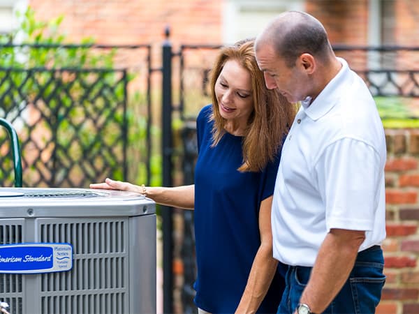 New air conditioning installation for Granite Bay homeowners Homeowners admiring their newly installed air conditioning unit in Granite Bay, CA