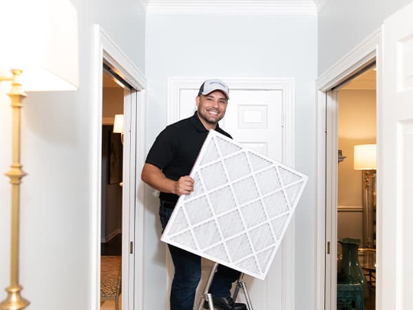 High-efficiency HVAC air filter for cleaner indoor air HVAC technician holding a new high-efficiency air filter for improved indoor air quality